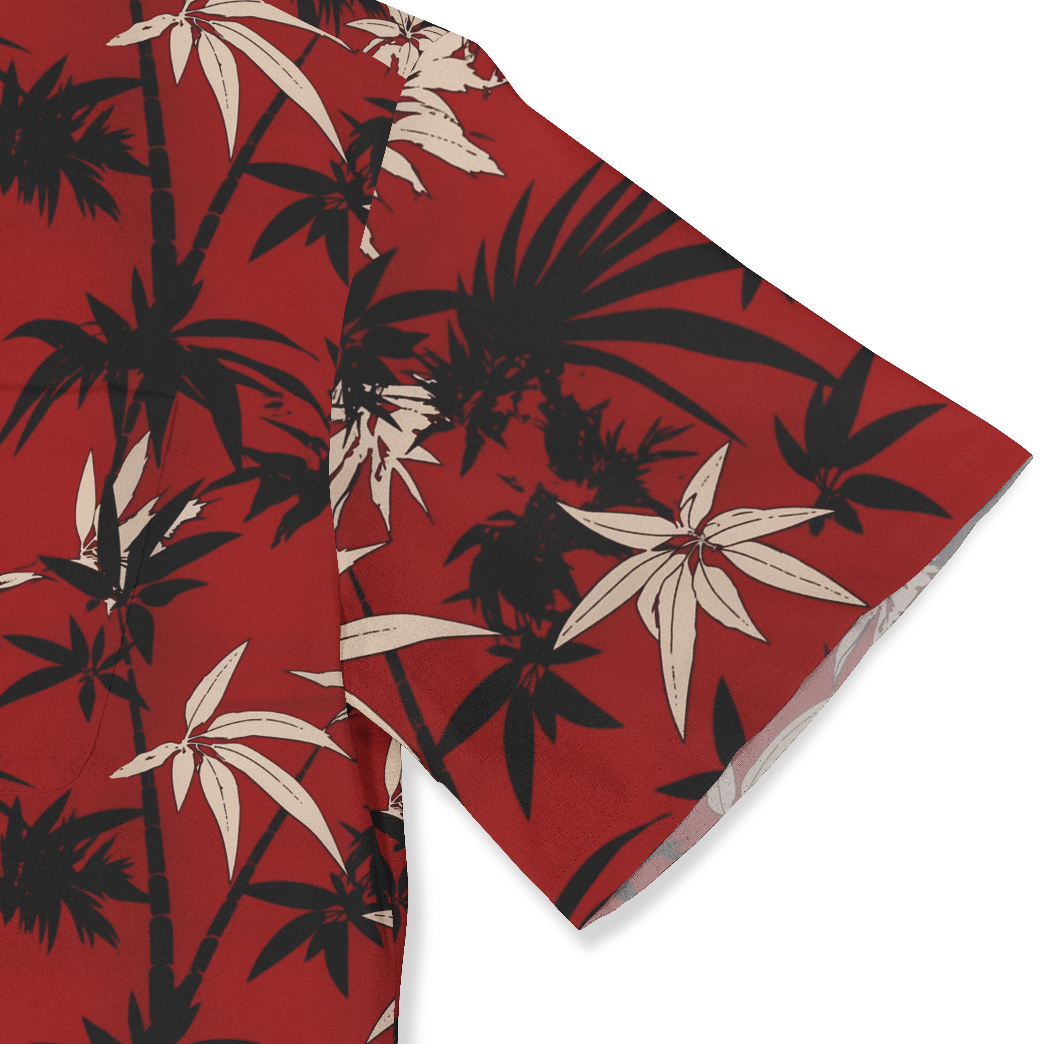 Red fabric with black and beige bamboo leaf pattern, folded corner.