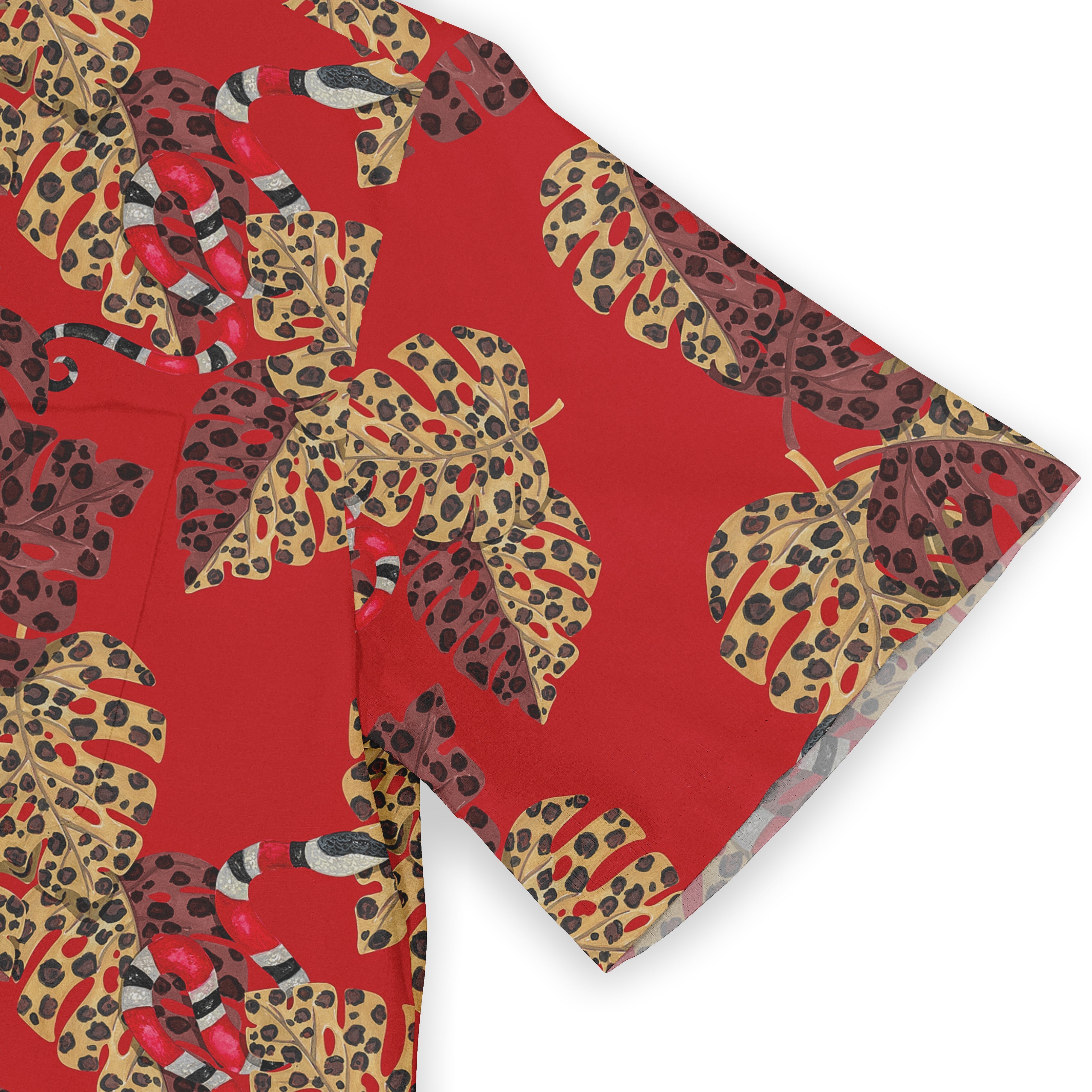 Red fabric with tropical leaf and snake pattern, featuring bold.