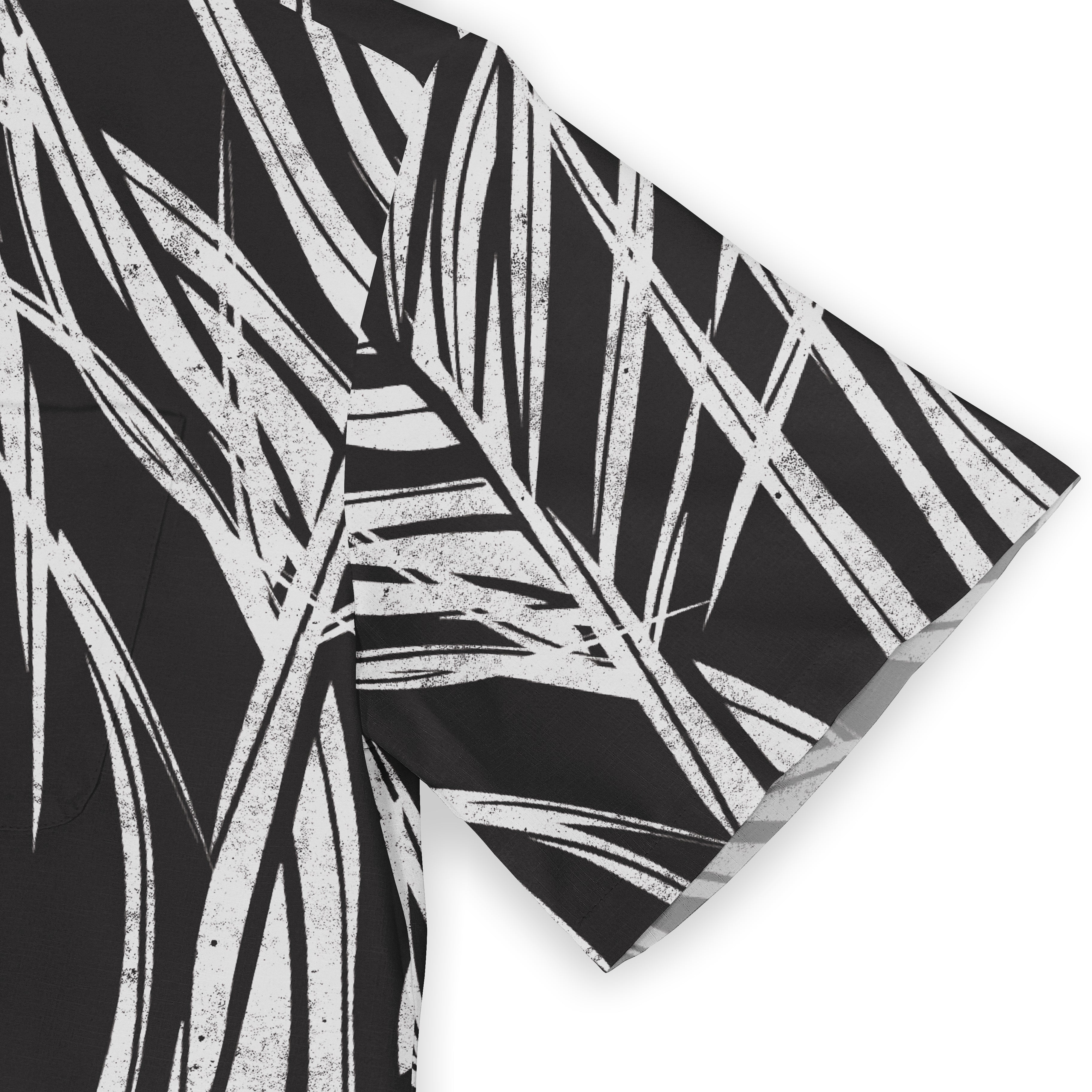 Black and white tropical leaf pattern on a fabric, likely a shirt or.