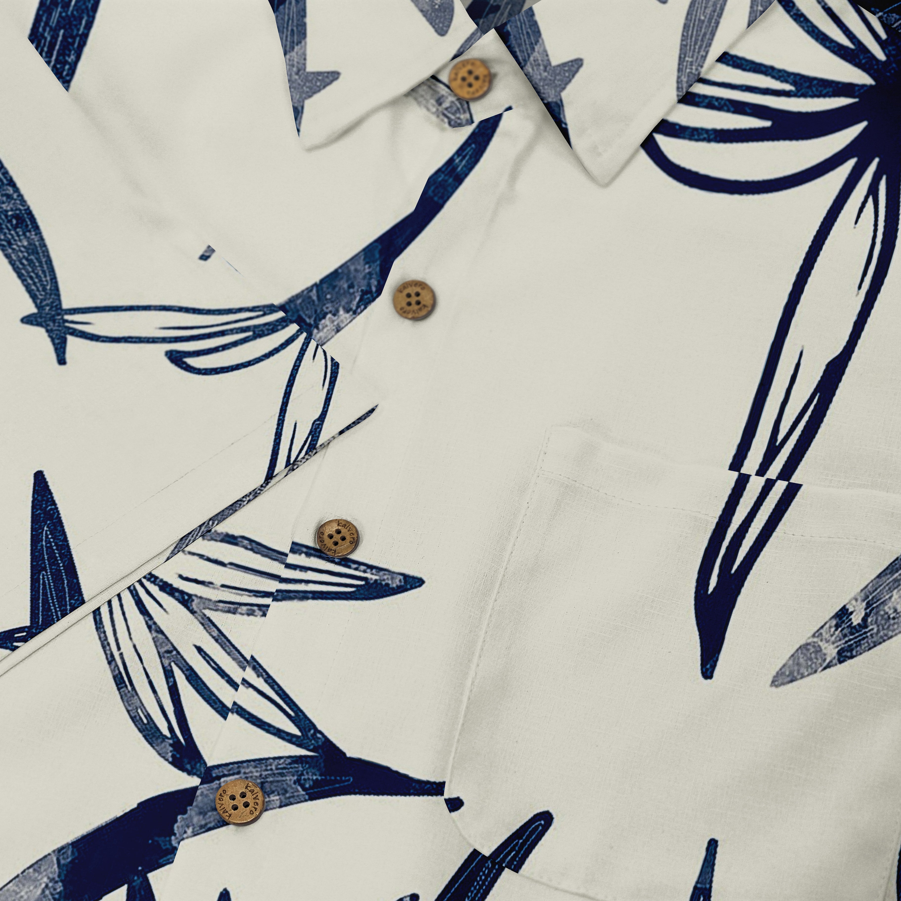 White shirt with blue tropical leaf print, wooden buttons.