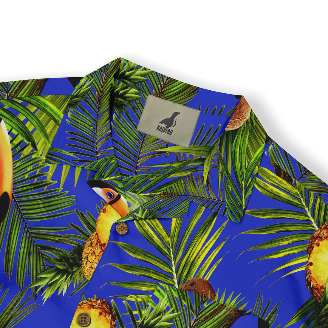 Vibrant blue shirt with tropical print featuring palm leaves.