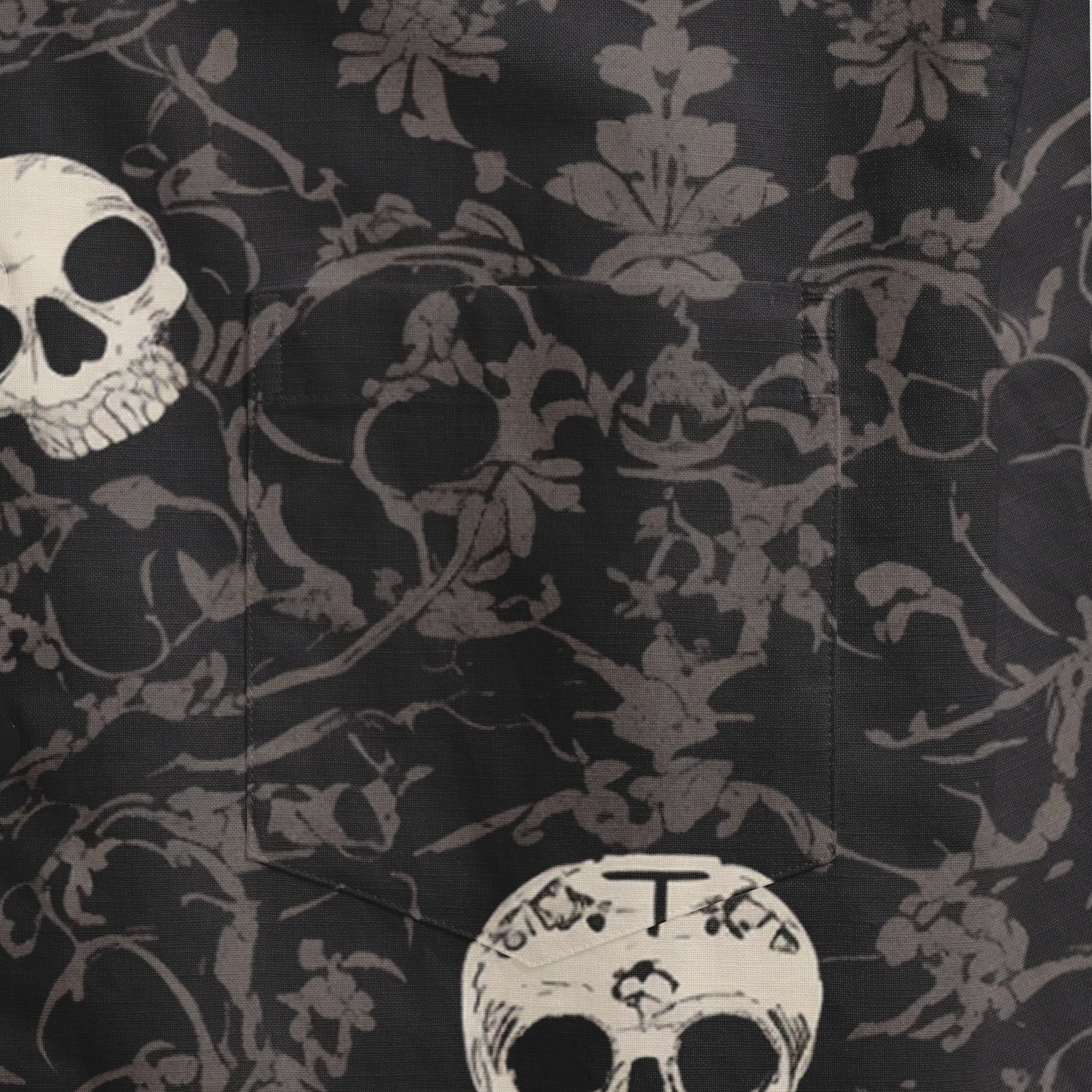 Black fabric with skull and floral pattern, featuring a pocket.