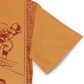 Orange fabric with red patterned border and illustrated figures.
