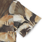 Tropical leaf patterned fabric in earthy tones, featuring brown.