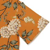 Orange floral fabric with beige flowers, green leaves, and purple.
