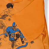 Orange polo shirt with graphic print of a football player.