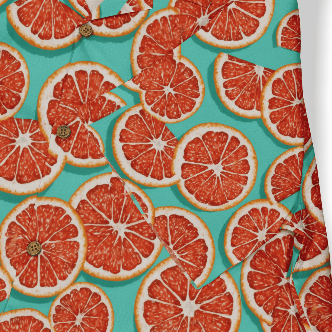 Vibrant citrus print shirt with red grapefruit slices on teal.