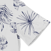 White fabric with navy blue tropical leaf print, featuring monstera.
