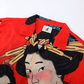 Red shirt with black hair, wooden sticks design.