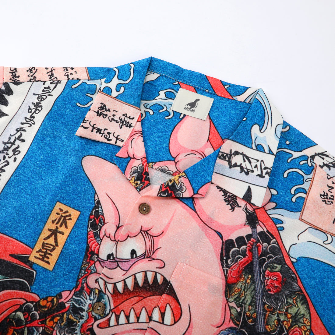 Blue shirt with pink demon design, Japanese text, and waves.