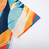 Colorful fabric with blue, orange, and white leaf patterns.
