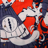 Orange shirt with cartoon clock design, blue stripes.