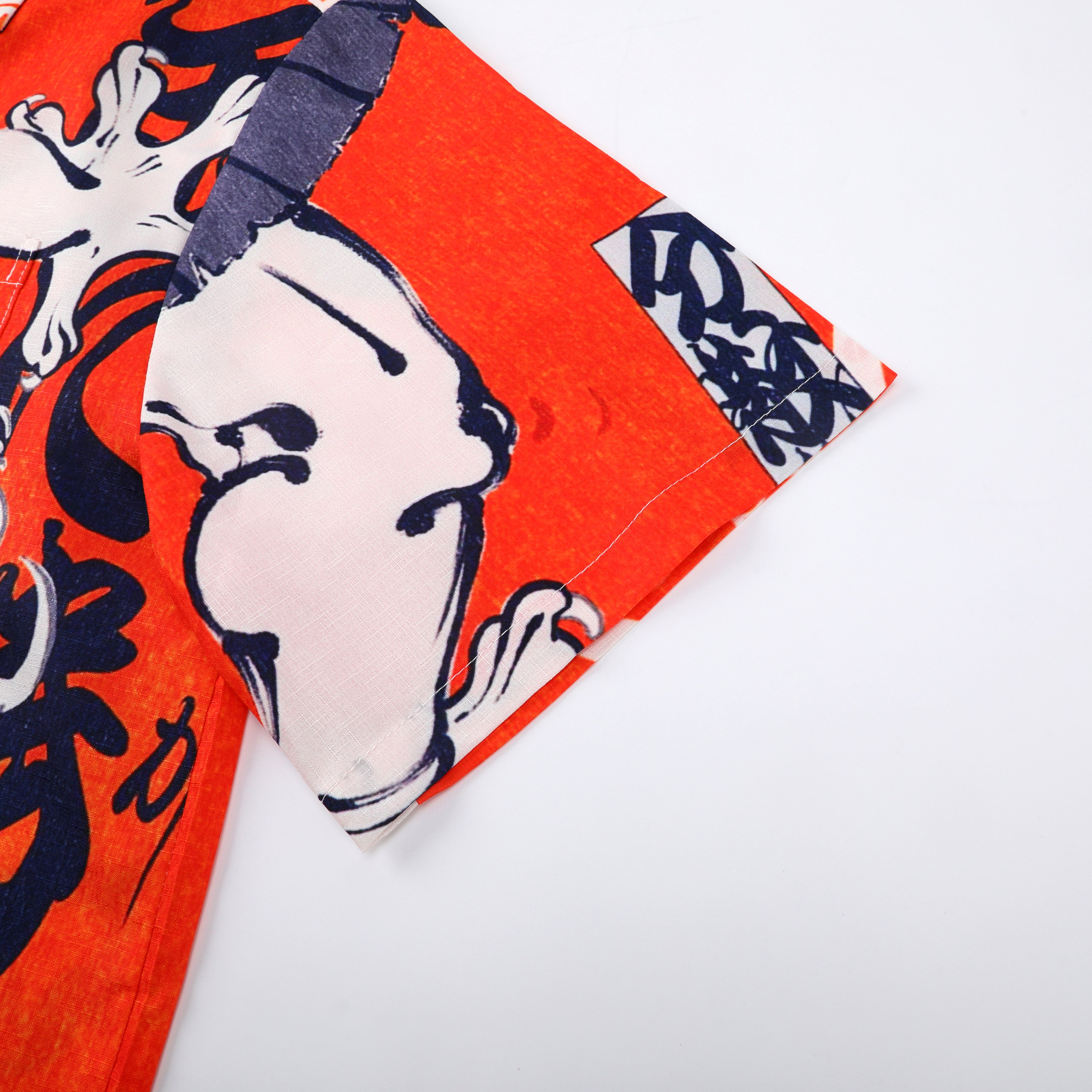 Orange fabric with abstract black and white design, folded corner.