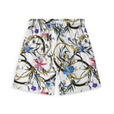 A pair of shorts featuring a design with gold chains, flowers, and botanical elements on a white background, creating a bold and luxurious look.