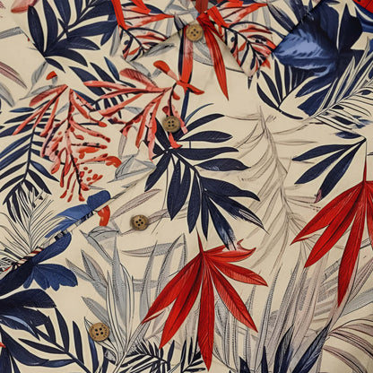 Beige shirt with bold, colorful tropical leaf prints.