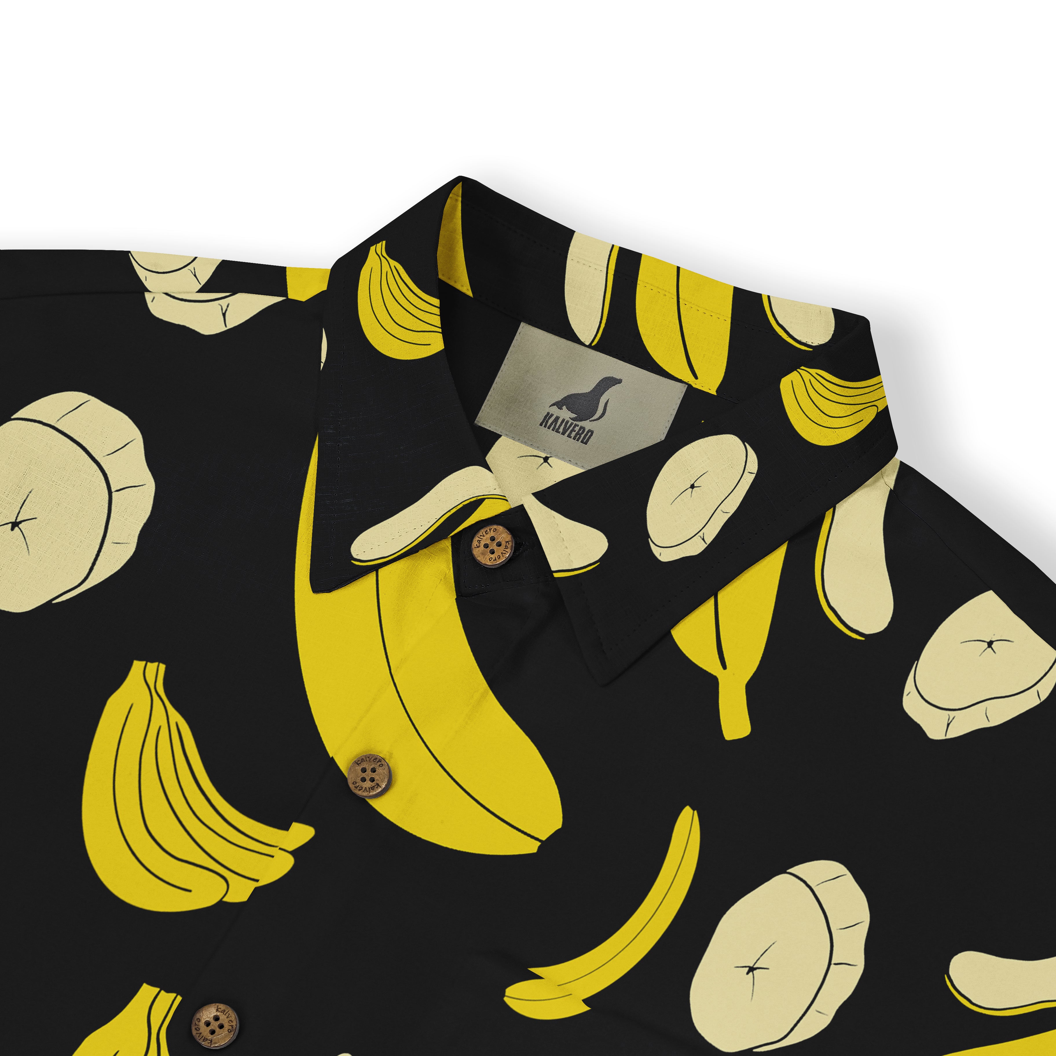 Close-up of a black shirt collar with a playful banana print featuring whole bananas and banana slices in yellow and cream colors.