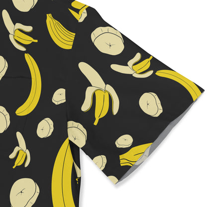 A sleeve of a black shirt featuring a whimsical banana print with whole bananas, peeled bananas, and banana slices in yellow and cream tones.