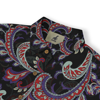 A close-up view of a shirt collar featuring a detailed paisley pattern in red, blue, and green on a black background. The intricate design includes swirling motifs and floral elements, showcasing the fabric&