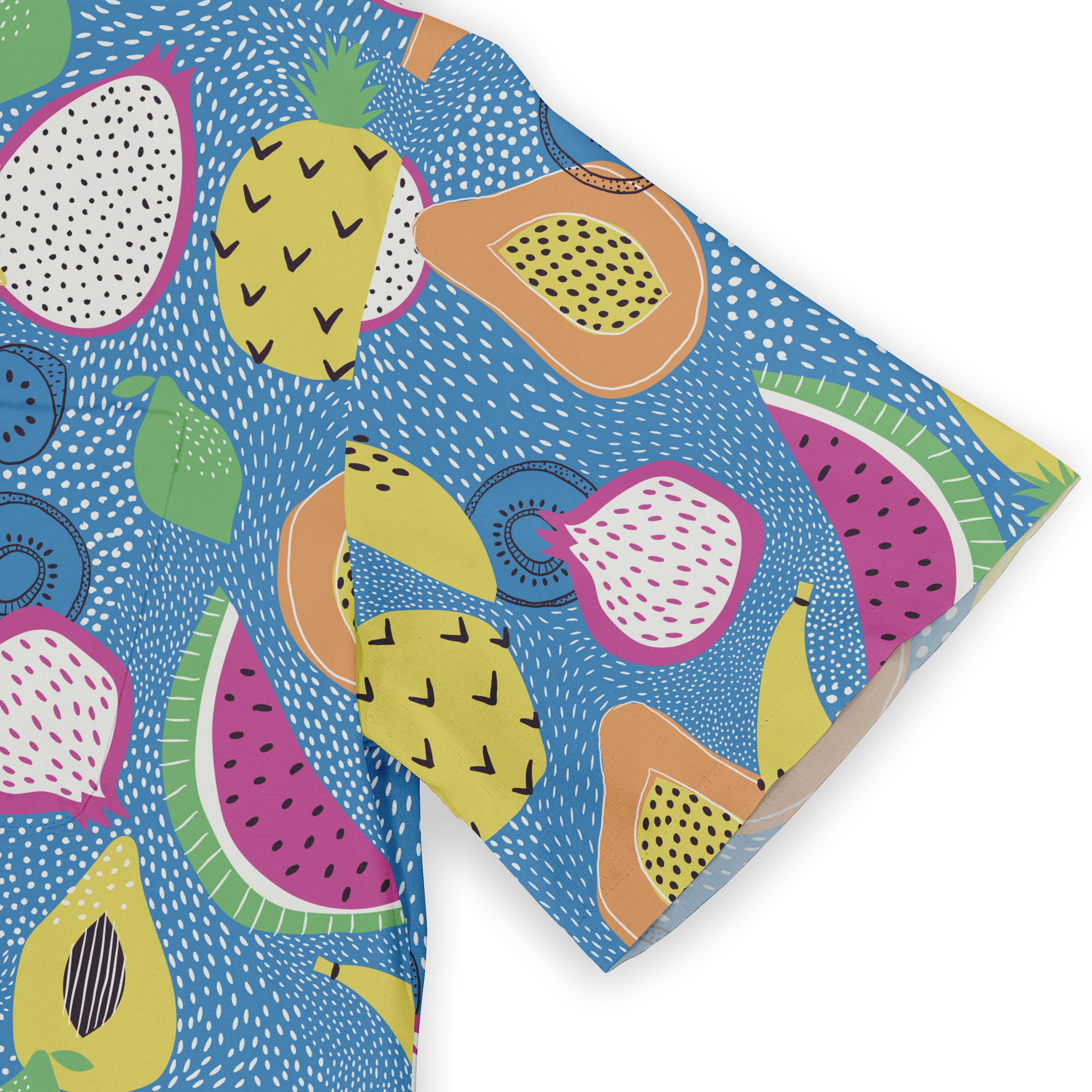 Close-up of the sleeve of a Hawaiian shirt featuring a vibrant fruit pattern with pineapples, dragon fruits, papayas, and other tropical elements on a blue background.