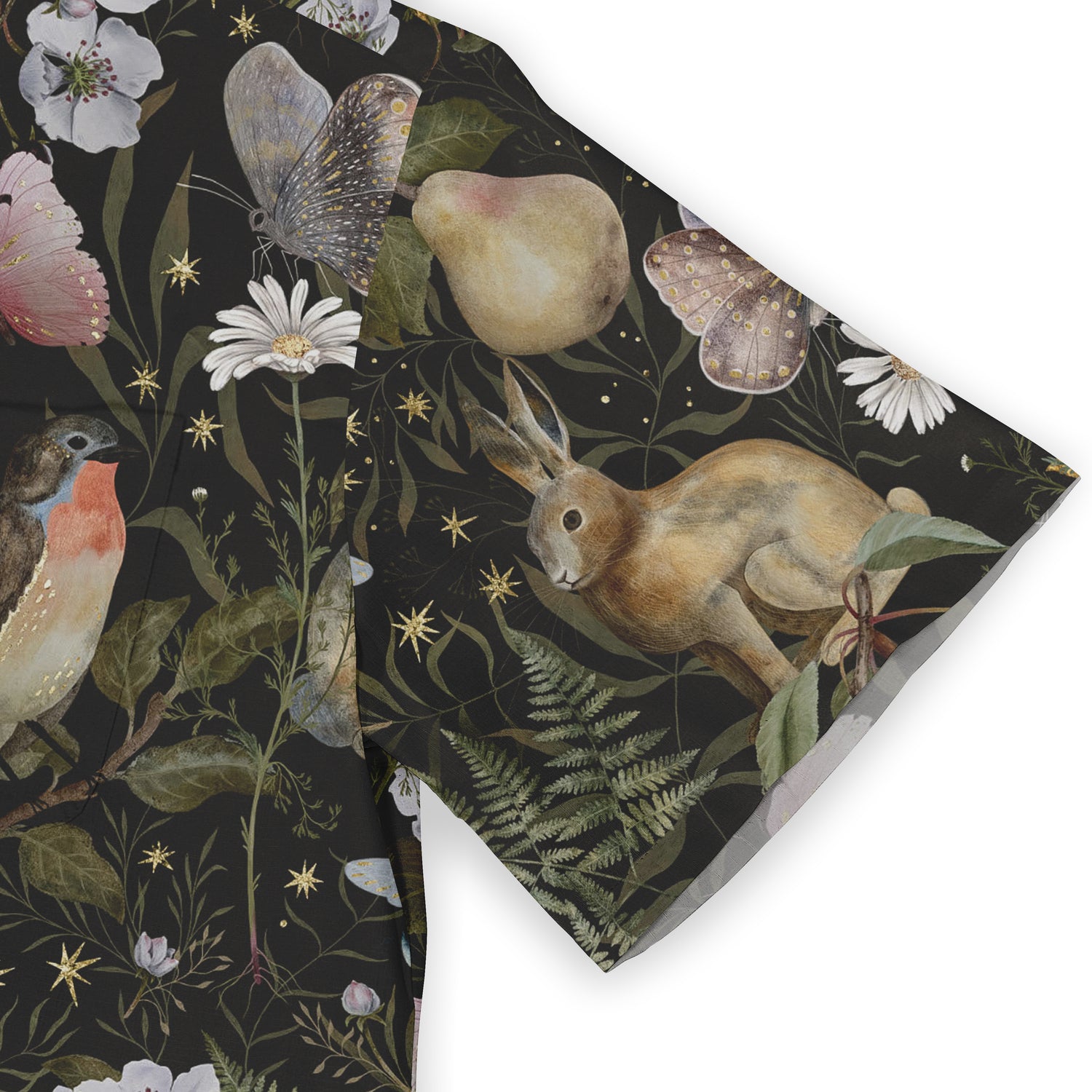 Close-up view of a shirt sleeve featuring an enchanting design with a rabbit, birds, butterflies, and delicate florals against a dark background.