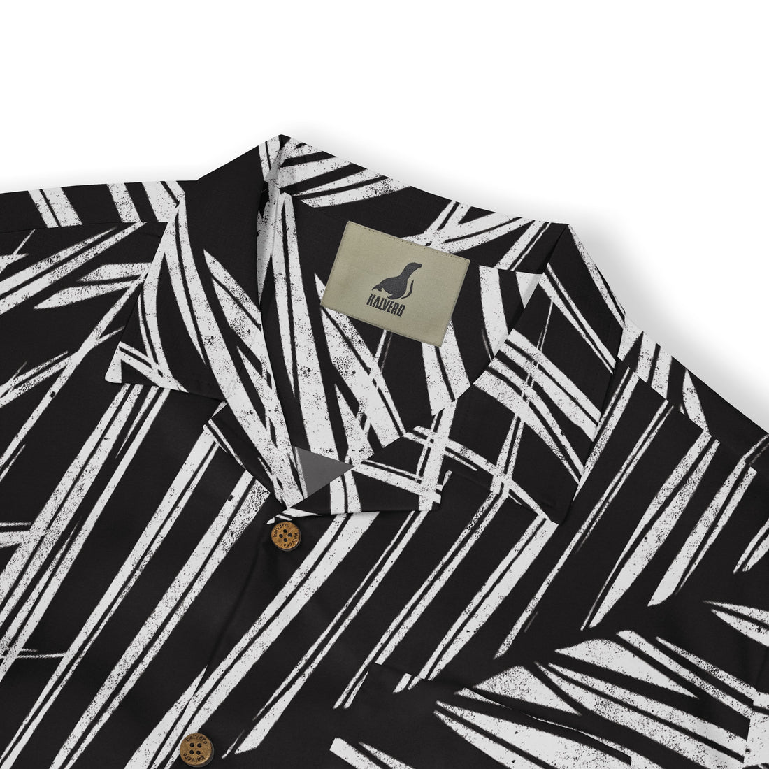 A close-up of a shirt collar featuring a bold white palm leaf pattern on a black background, with a &quot;Kalvero&quot; label visible.