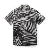 A shirt with a bold design featuring white palm leaf patterns on a black background, creating a striking monochrome look.