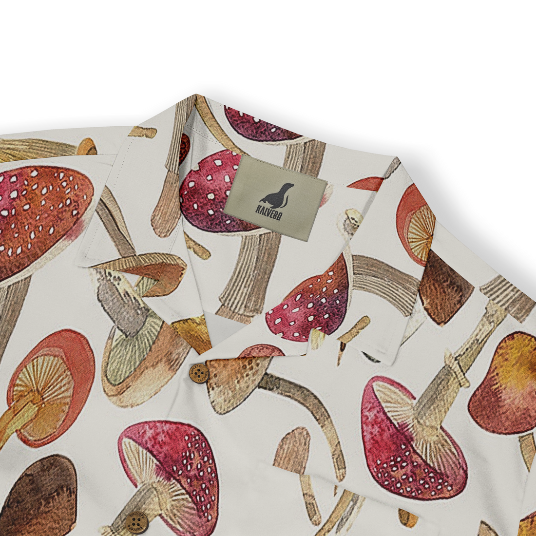 Close-up of a white shirt featuring a whimsical mushroom pattern in earthy tones, showcasing details like red caps with white spots and various shades of brown and beige.