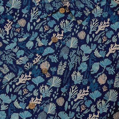 Deep blue shirt with delicate coral and seaweed illustrations depicting a nighttime ocean scene front buttons close-up