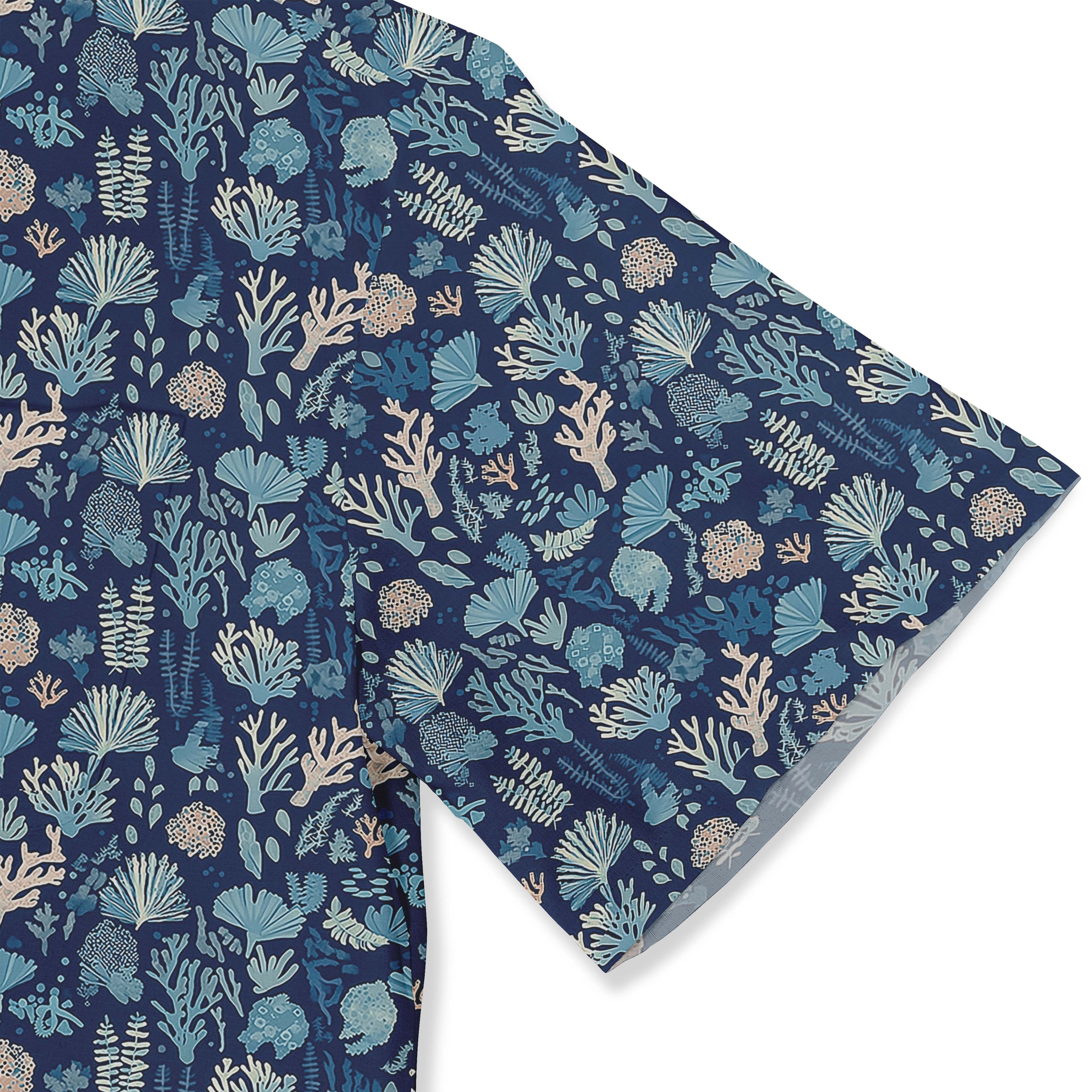 Deep blue shirt with delicate coral and seaweed illustrations depicting a nighttime ocean scene sleeve close-up