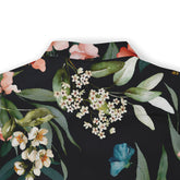 Back of a floral shirt featuring delicate white flowers, green leaves, and a pop of blue on a black background.