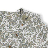 A short-sleeved shirt with a "Serenity Scrolls" pattern, featuring blue and white paisley motifs and floral vines framed by geometric borders front view