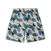 Shorts with a light beige background featuring blue leaves and toucans, embodying a tropical vibe.