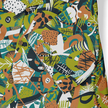 This is a close-up of a shirt featuring a vibrant abstract design in green, orange, black, and white. The pattern includes various geometric shapes and leaves, with details like wooden buttons, creating a lively and dynamic style.