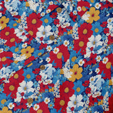 Colorful floral fabric with red, blue, yellow flowers and buttons.