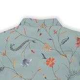 Back view of a light green shirt featuring an intricate floral and botanical print with vibrant flowers, leaves, and delicate branches, showcasing a nature-inspired design.