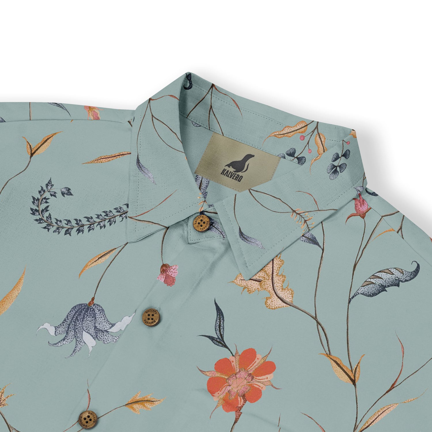 Close-up of a light green shirt collar with a delicate floral design, featuring thin branches, colorful flowers, and detailed stitching, adding a touch of elegance.